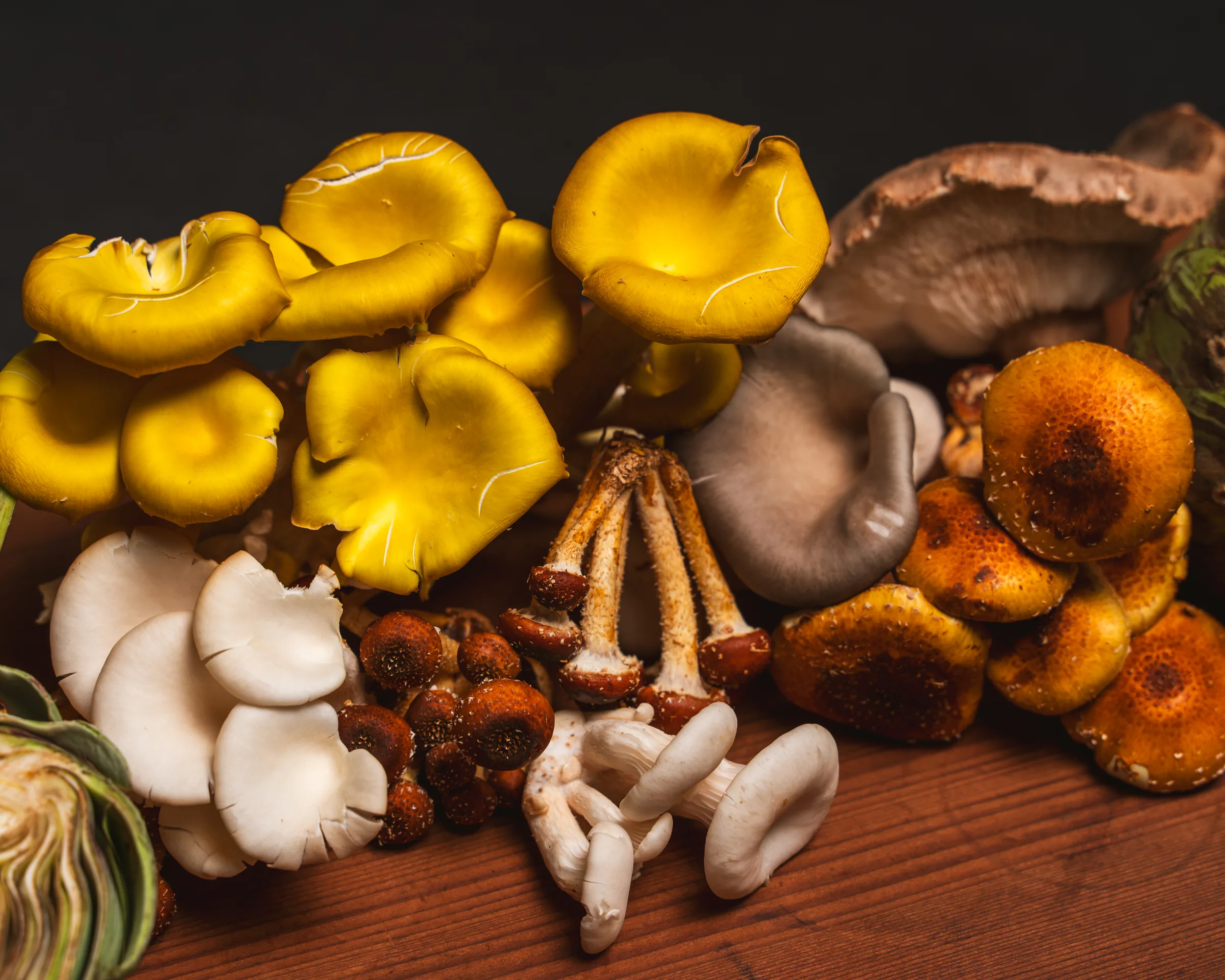 Foraged mushrooms in yellow and brown on a wooden board