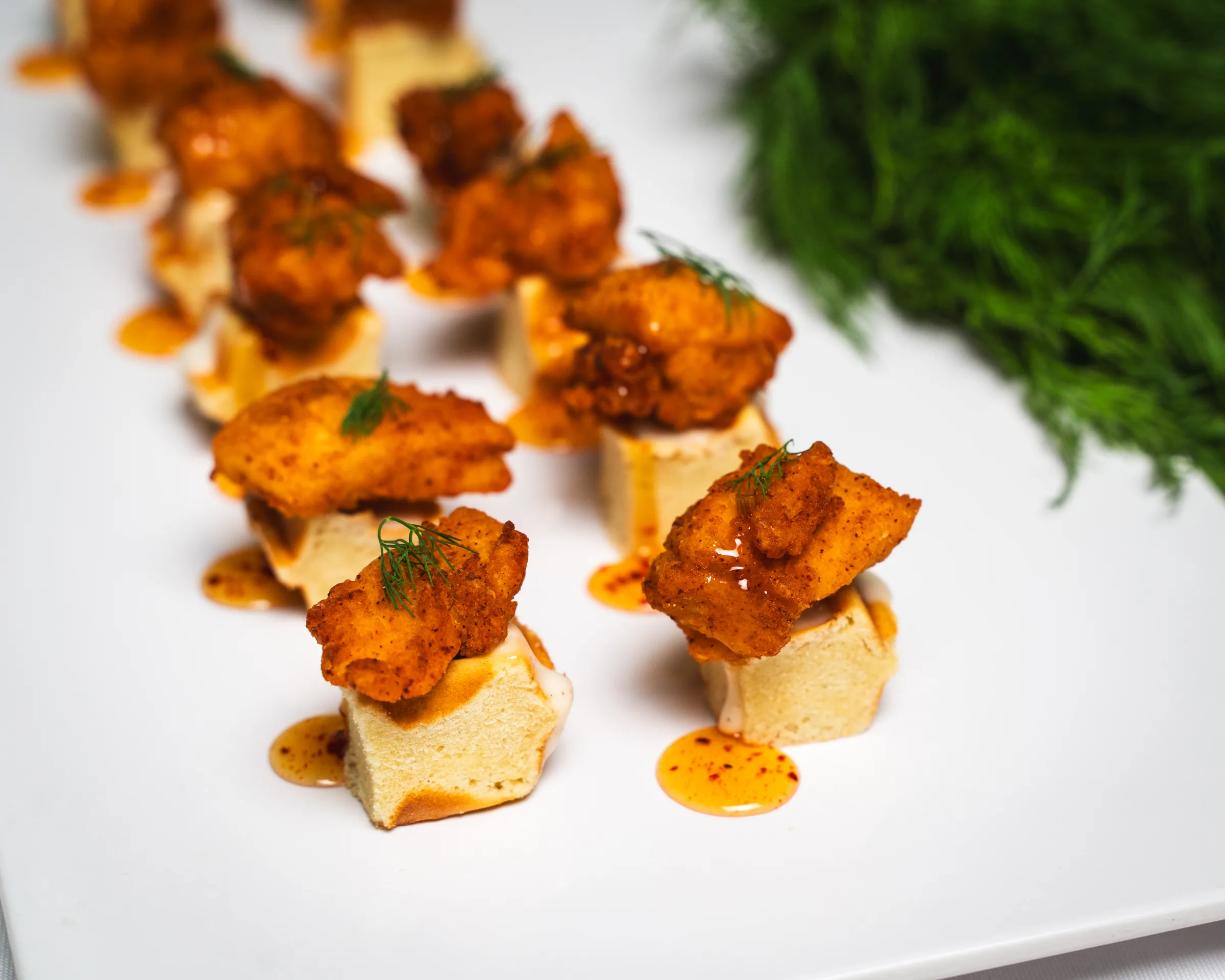 Chicken and waffle bites with hot honey on skewers